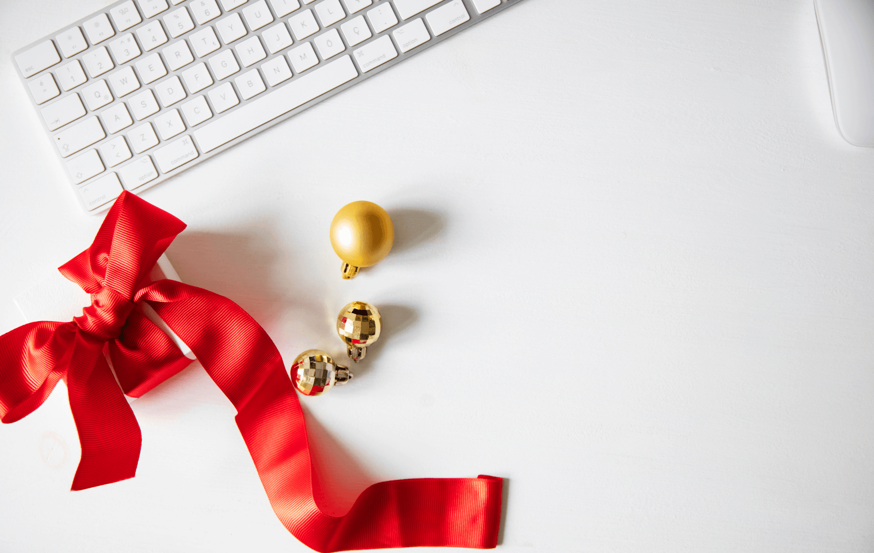 A holiday bow sitting next to a laptop.png