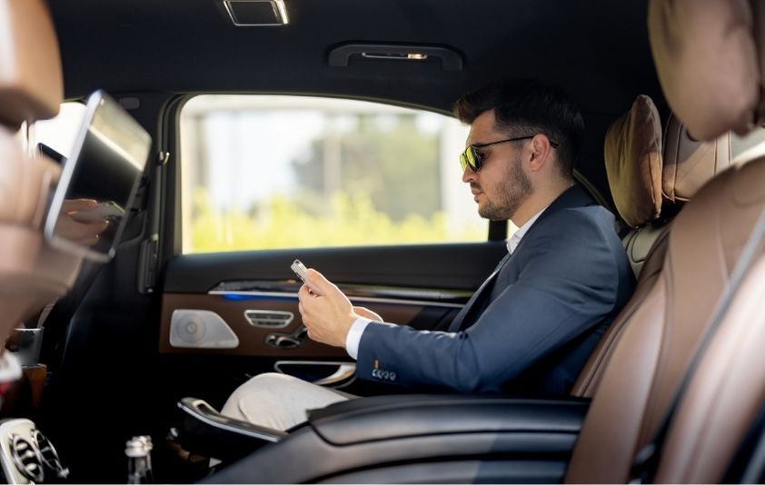 A man sitting comfortably in his luxury black car transfer