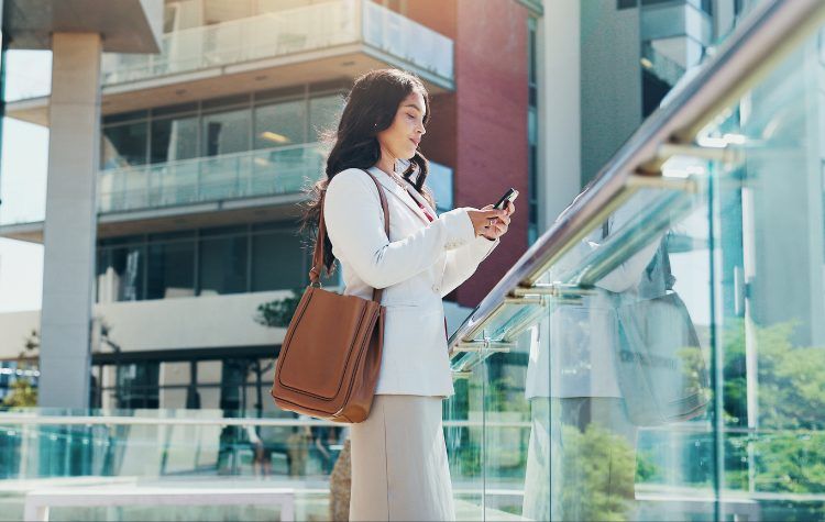 A woman traveling checking her phone for updates