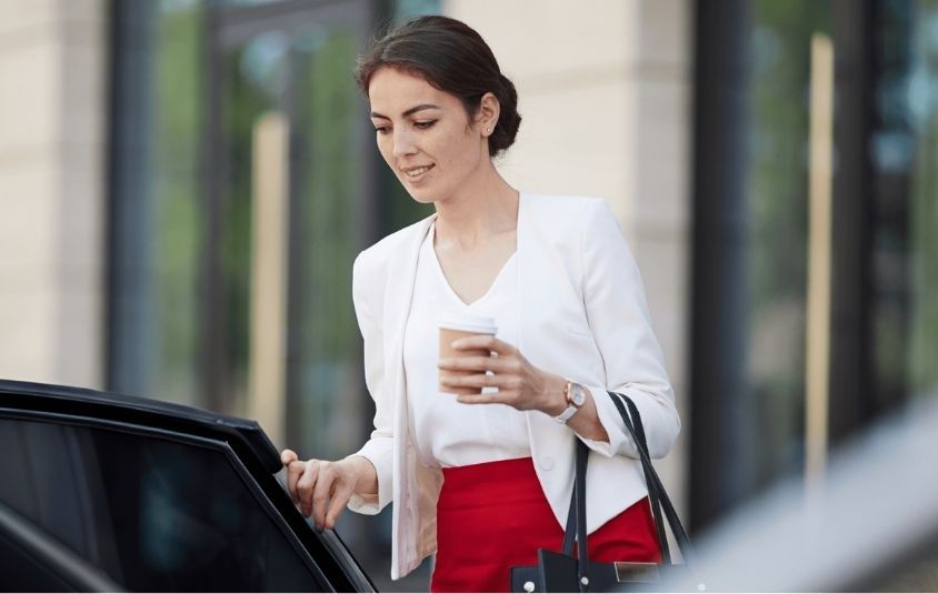Businesswoman getting into a car