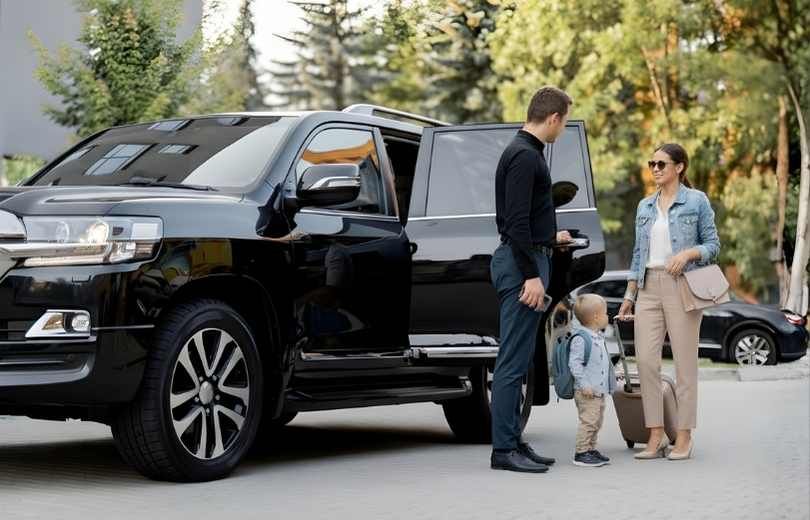 Chauffeur helping passengers into a car