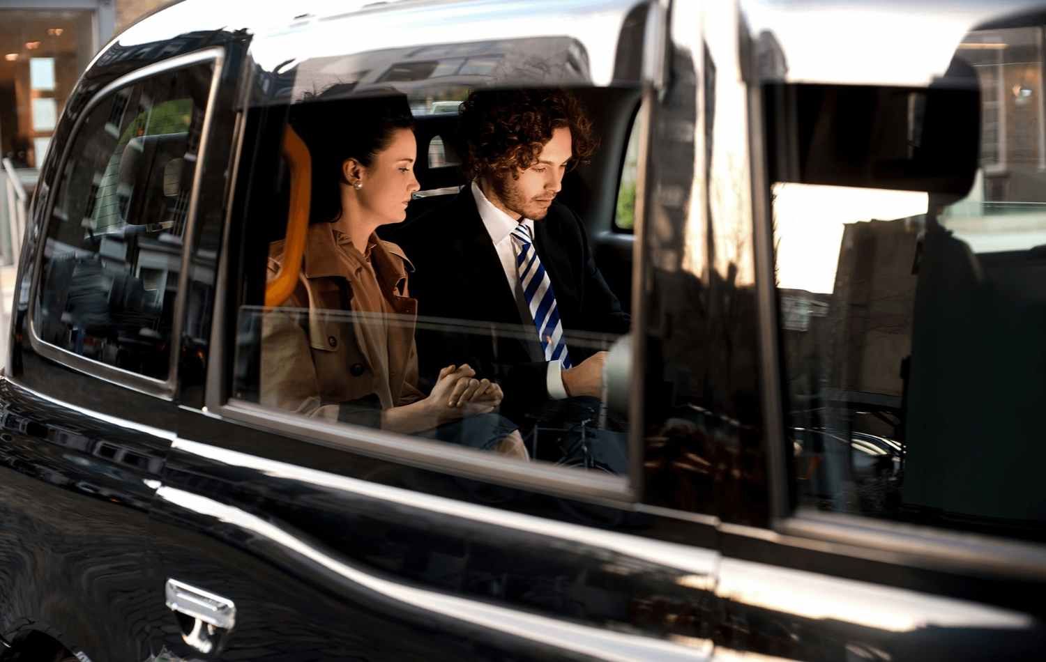 Two colleagues in the back of a black car SUV