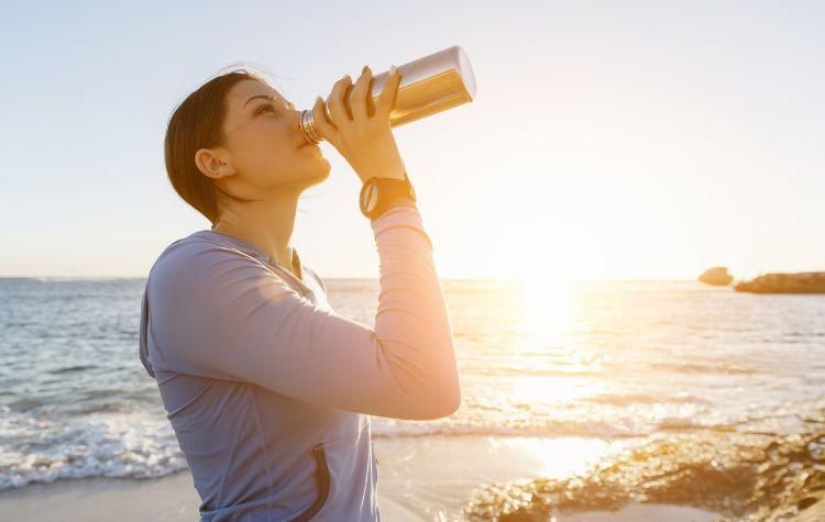 Women drinking water on the beach