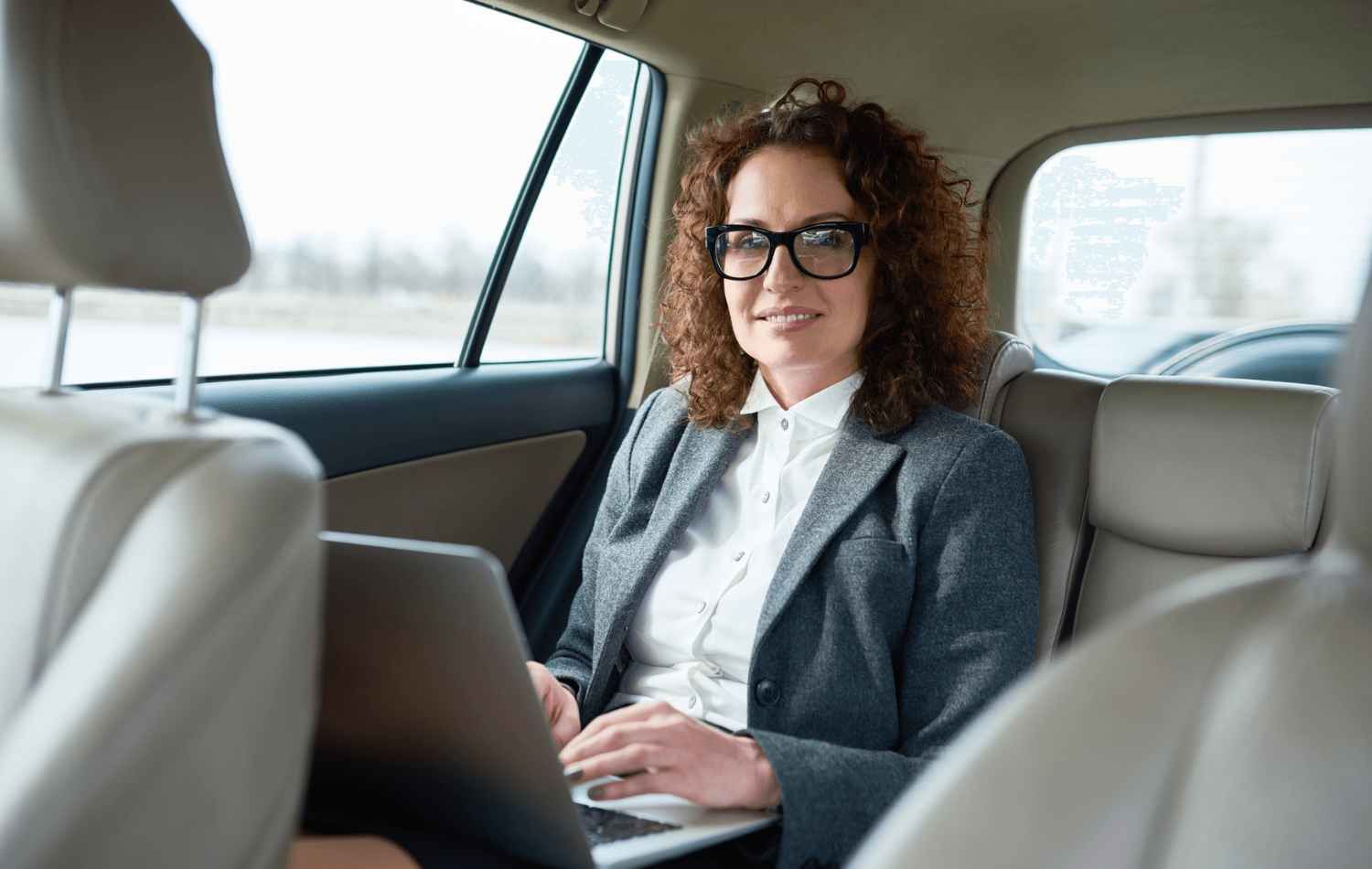 Woman sitting in the back seat of a black car transfer